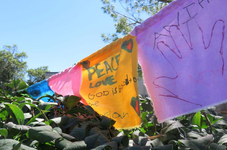 Hand-made banners promoting peace and community line a bush beside the site of Micheal Browns death. A sprawling memorial with signs and objects in honor of Brown have been erected along the street.
