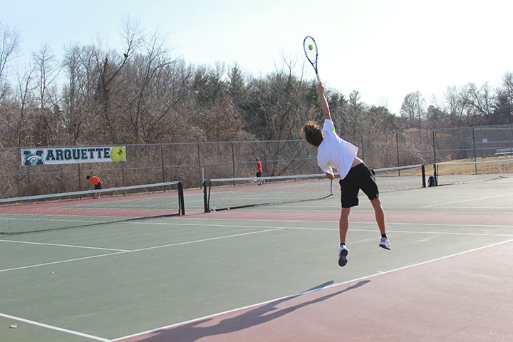 Trenton Wherry, sophomore, hits a serve during boys varsity tennis tryouts on Mar. 11, 2015. 
