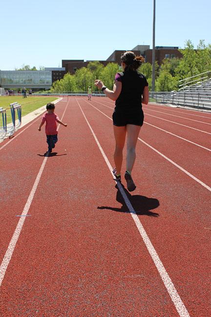Mrs. Holman, biology teacher, runs with her son, Hendrix, on the track during Bring your kid to work day. 