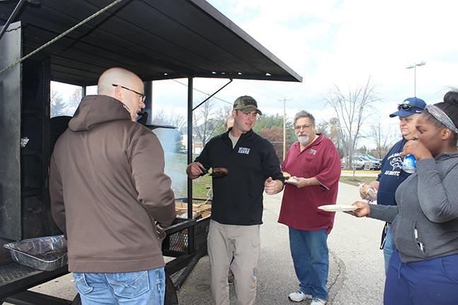 Sergeant Mayberry hands a hamburger to one of the MHS staff member’s enjoying the Army National Guard barbeque.
