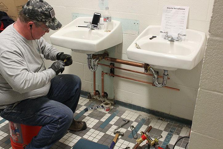 A plumber adds two new sinks to the third floor C-wing male bathroom. The sinks in the bathroom had lost all function for a few weeks before and after spring break.
