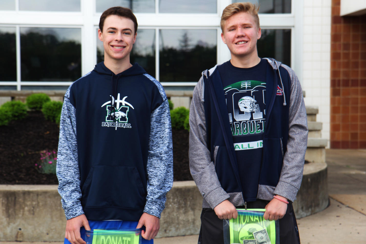 Left to Right: Drew Sears, sophomore and Ross Matzen, sophomore, collect donation funds for Eureka High Schools flood rejuvenation efforts. They are two of many students working with Amy Doyle, social studies teacher.