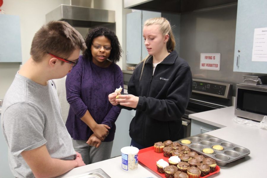 Brendan Morris and Lindsey Scales, juniors, work with Bryah Trenn, junior, to ice cupcakes in their fifth hour Life After High School class.