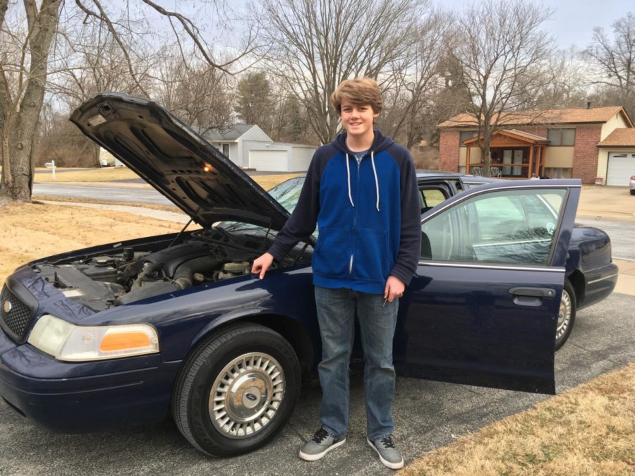 Hawke Hood, sophomore, poses with his Crown Victoria.