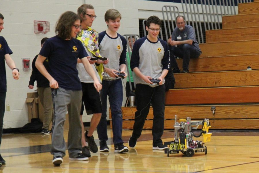 Sam Droney, Senior, Mike Spohr, Junior, and Adam Cohen, Sophomore, guide the Baryons Robotics teams Robot that won nationals.