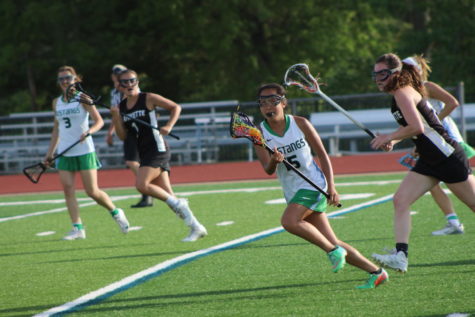 Kailyn Lee, Junior, cradles the ball up to midfield, following an LHS scoring attempt. MHS won this game, 14-9.
