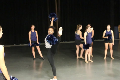 Sam Hall, sophomore, performs a battement with poms. Hall is a ballet dancer who spent a day with the MHS poms team to experience a style of dance foreign to her.  