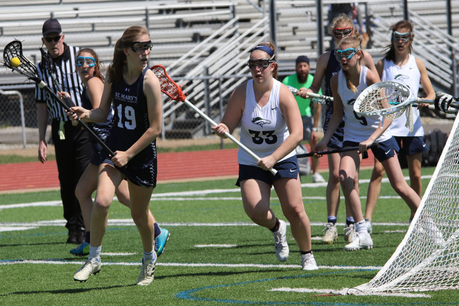 Megan Beshore, junior, defends the goal against St. Mary’s. They won this game and later went on to beat MICDS 14-13. “We have been working extremely hard this season, and it is definitely paying off,” Beshore said.