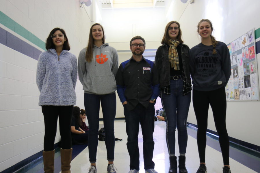 Zoë Malik, junior, stands on the left next to Ally Fitzgerald, sophomore. Katie Weiss, senior, poses on the far right, with Kira Mangan, senior, on the left of her. Ed Bolton, chemistry teacher, is 5 7 and agreed to be used for reference in the picture.