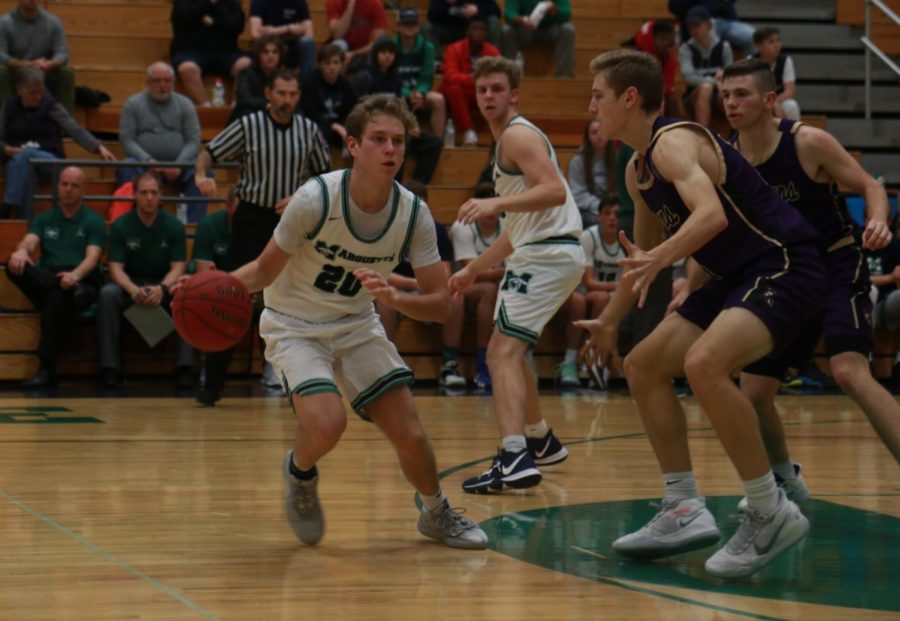 Cole Petch, junior, prepares to pass the ball off during the teams game against Troy Buchanan. Petch shot 3 for 3 and scored 8 points in that game.