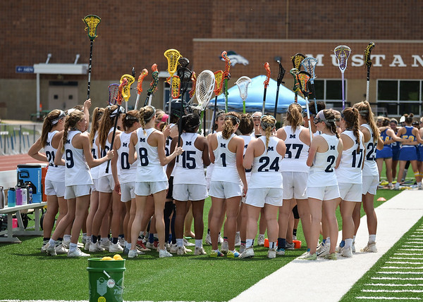 The varsity lacrosse team raises their sticks before a match against Francis Howell in 2019. This was Coach Chris Elledges final year of head coaching for the varsity lacrosse team, and Coach Renee Abrolats final year as the assistant coach before being promoted to head coach for the 2020 season.