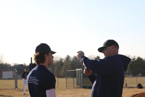 Coach Meyer helps Matthew Andrews work on his throw. Meyer observed potential players as they tried out for the upcoming baseball season. 