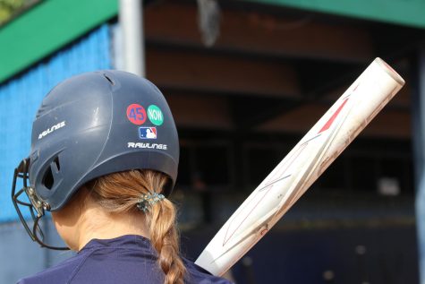 Natalie Danner, junior, steps up to bat at practice while dawning a sticker in remembrance of former Assistant Principal Carl Hudson, who passed away in December of 2021, on her helmet. The inspiration of these stickers stem from Hudsons love for the St. Louis Cardinals and MHS.