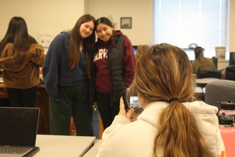 Emma Hayes, junior, takes a picture of two yearbook members for an Instagram post. She runs the account with Laura Carlton, junior, where they try to post at least 2 times a week. 
