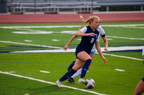 Running with the ball, Ava Talley, junior, scored one goal against Parkway West. Talley has 4 points this year and has scored 2 game-winning goals.
