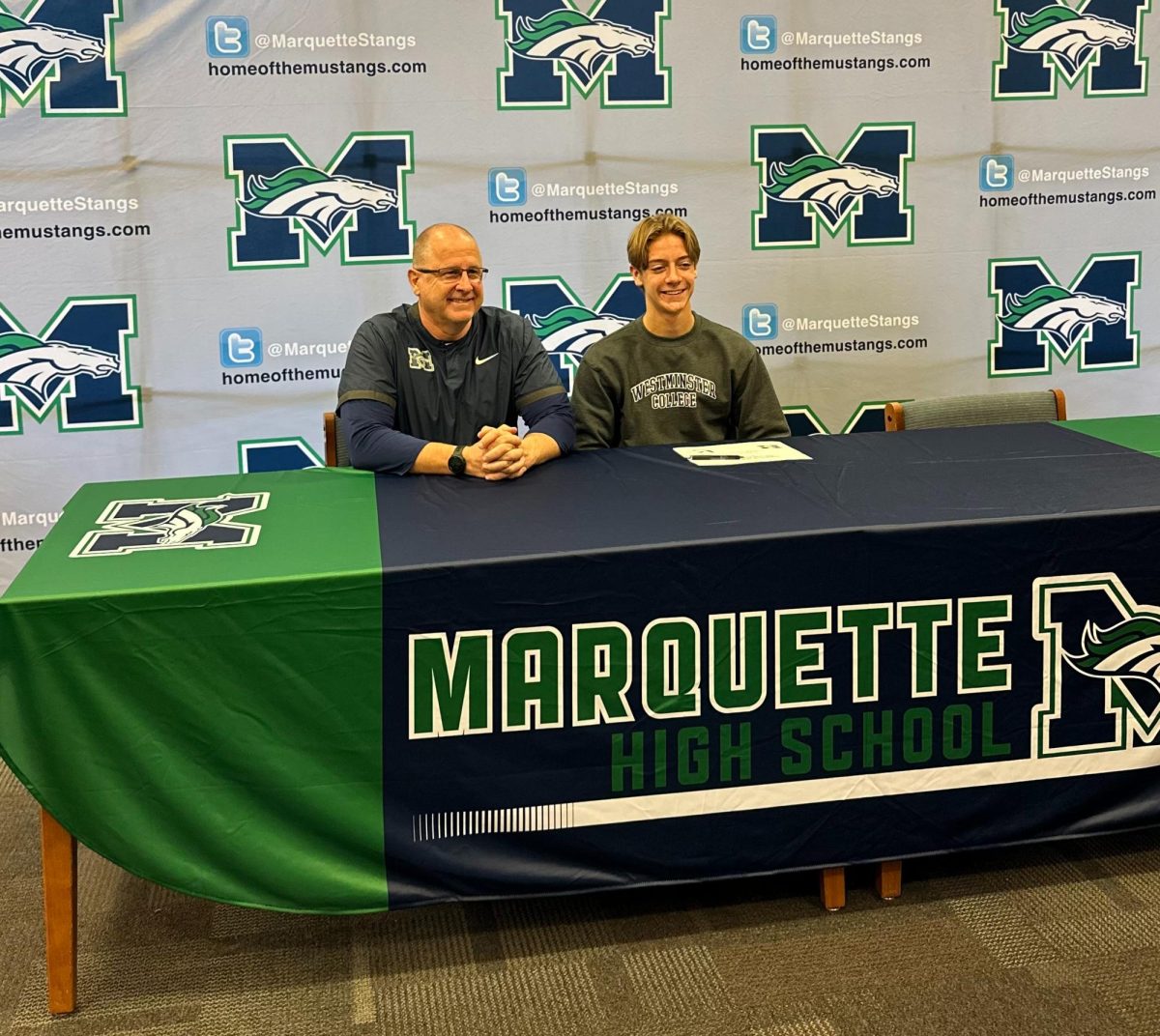 Colyn Wright, senior, takes his seat beside head varsity baseball coach John Meyer on Monday, Nov. 27. Wright signed to play baseball for Westminster College in the fall.