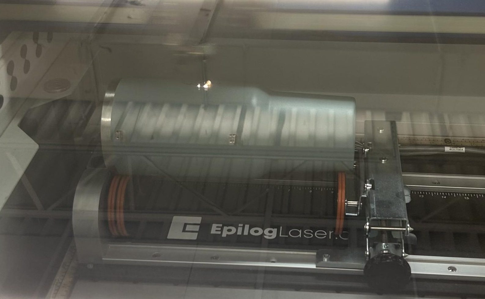 The engraving machine takes over to etch the design into the cup.