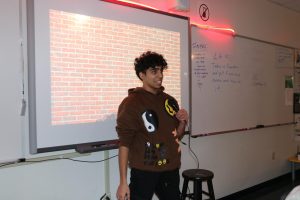 Kabir Ghura, senior, stands at the front of the class, holding the microphone, eager to share his jokes. Ghura won first place in the stand-up comedy competition, and one of Rob Durham, creative writing teacher's, book.