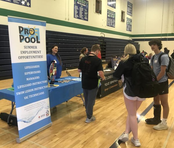 Mathew Dupree, senior, discusses job opportunities with representatives from Pro Pool, a swimming pool service company.
