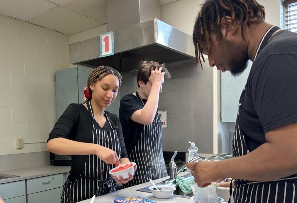 Seniors Eeliyah Borland, Brady Payne and Frederick McCullough II work together to prepare icing to decorate their cupcakes. Their theme was Sesame Street.