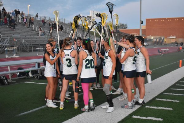 Varsity lacrosse players huddle up before their game against Rockwood Summit. Both Lally and Haas scored their 100 goal on senior night.  Photograph by Katherine Schroeder
