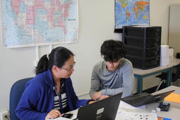 Yan Zhao, assistant ESOL teacher, helps an ESOL student. The program uses various strategies, such as modifying phrases, to assist these students in understanding English assignments.