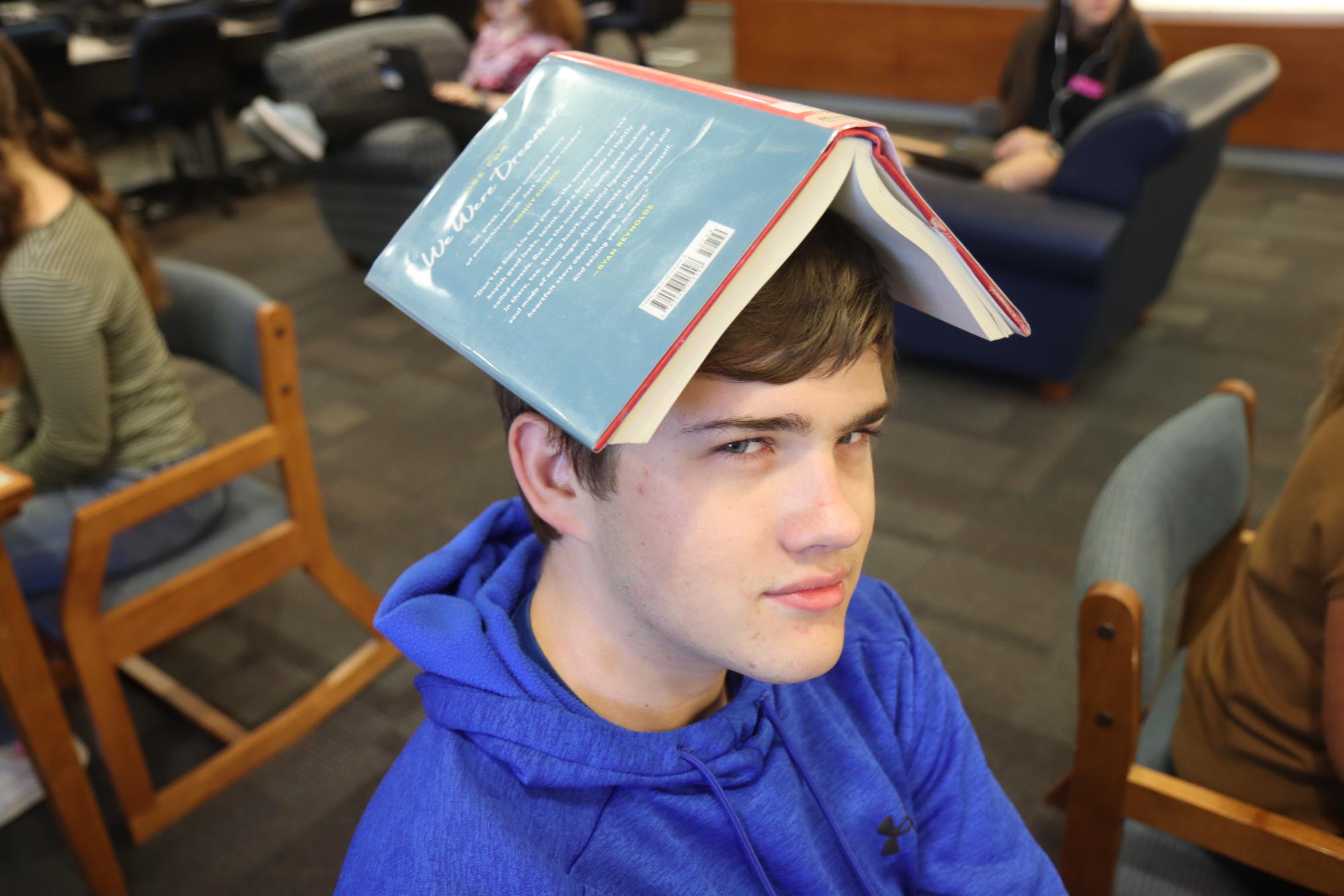 Caleb Stockman reads "We Were Dreamers" by Simu Liu in the library during his first hour language arts class.