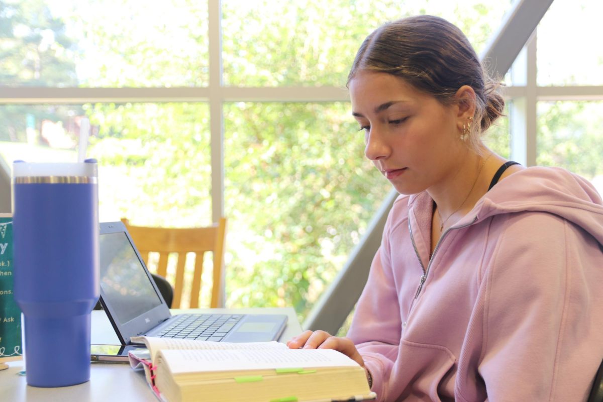 Sydney Vacarro readers her independent reading novel in the library during first hour language arts.