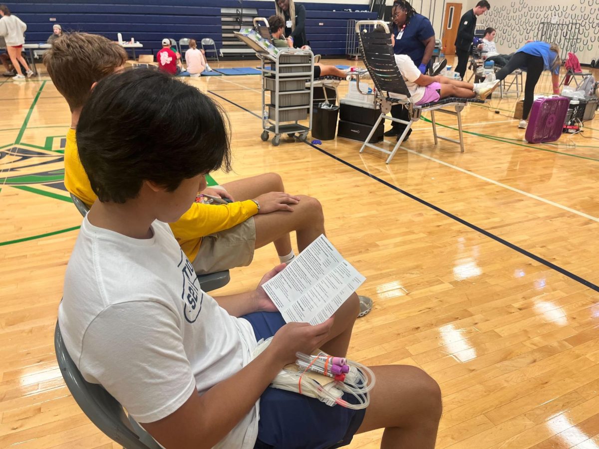 A.J. Hirang, senior, waits to have his blood collected in the small gym. Students who wanted to donate blood required parental consent. 