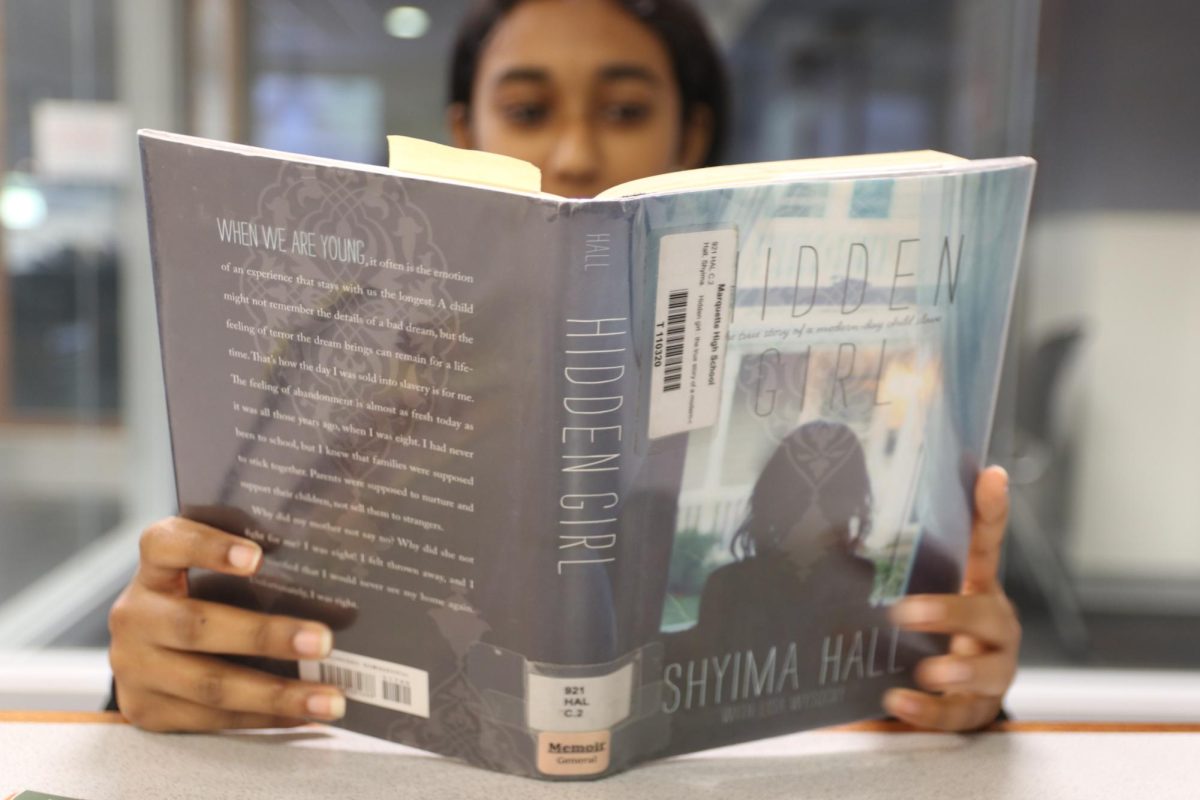 Sree Senthilnathan, sophomore, reads the memoir "Hidden Girl" by Shyima Hall in the library during her language arts class. Language arts classes are now visiting the library every three weeks for designated reading time as part of the initiative to increase students' literacy skills.