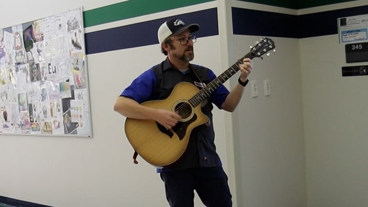 Ed Bolton, known for playing guitar outside his chemistry classroom, helps out the marching band after hours.