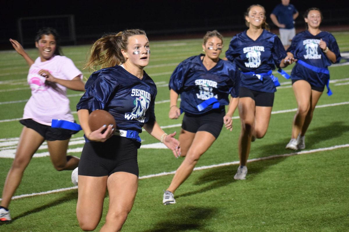 Marin Lally, senior, runs with the football to the endzone to score for the senior team at the Powderpuff game.