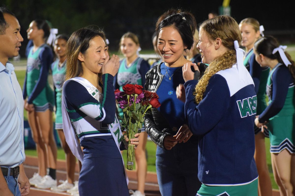 Naomi Feng, senior, gets emotional after her teammate hands her flowers. “Just getting to see my parents was a very emotional moment for me, and then also lining up and seeing not only my teammates, but also my friends, supporting me was really nice to see,” Feng said.