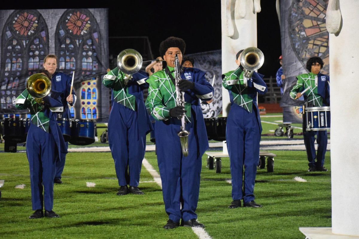 Junior Carter Walton, bass clarinet, performs with the rest of the Marching Band on Friday, Sept. 27. The band's show is called Illuminations.