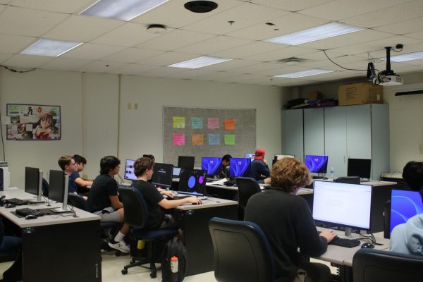 Students watch a video about phone scams on a SMART Board while working on a project about online scams and identity theft during the fourth hour cybersecurity class on Friday, Sept. 13. Chief Information Officer Bob Deneau said suspicious links are often the root cause of large cyberthreats.