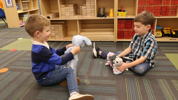 Pre-schoolers Benny Bartoe and Alex Sturges play with their stuffed animals, a dog named Puppy Blue and cats, Binks (gray), Jenny (rainbow) and Bell (pink).