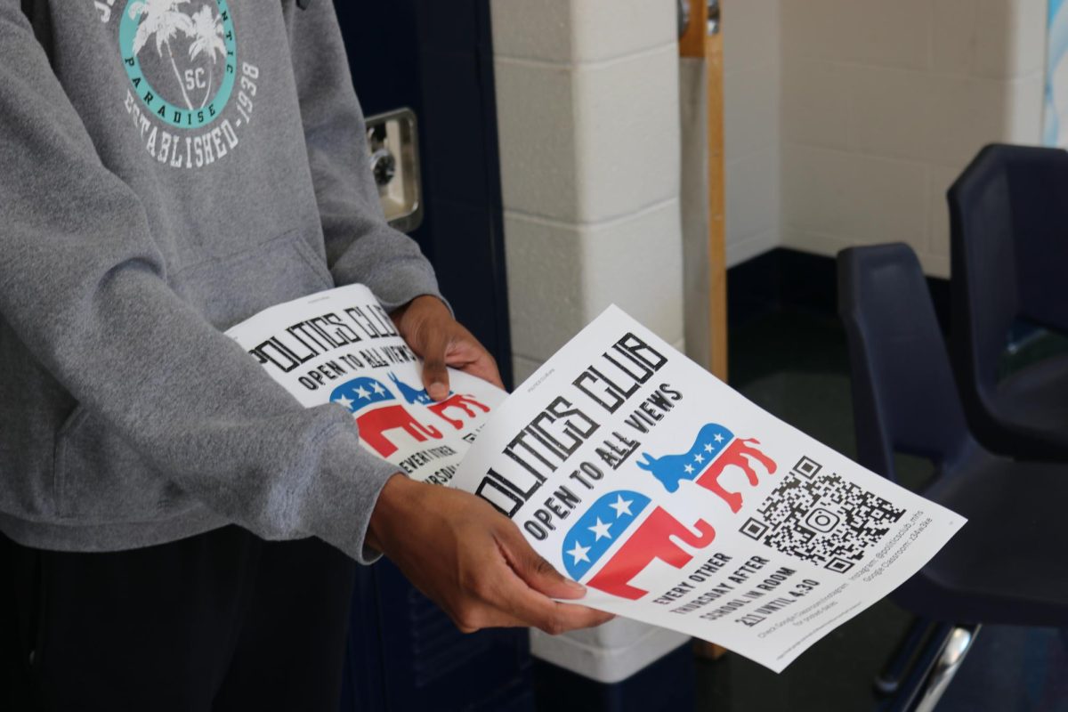 Sohum Tokekar, senior, hands out flyers for Politics Club during the Activities Fair on Wednesday, Sept. 25. Tokekar is vice president of the club and said the role of social media in politics is brought up often during meetings.