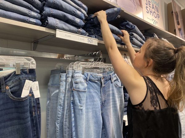 Leah Cassely, senior, restocks the selection of flared jeans in Maurices, the clothing store she manages.  