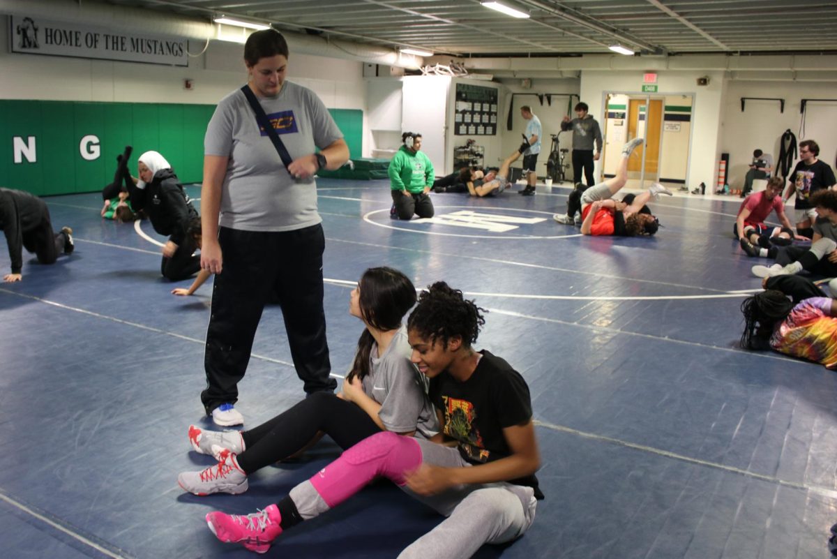 Juniors Mehrou Darish and Leah Bazile wrestling during practice after school on Tuesday, Dec. 3, under the supervision of coach Kristi Rutsch. Money from a Greg Warren fundraising event scheduled for Tuesday, Jan. 21, will go toward buying new uniforms and equipment for the team. 
