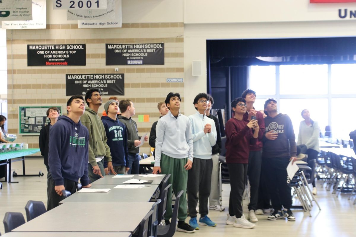 Students look up to the third floor in anticipation as the last egg is dropped for 7th hour AP Physics 1 class. The class that has the highest performance score of all of the AP Physics 1 hours gets either a pizza or pancake party, and the option to skip out on an AP Physics 1 homework assignment.