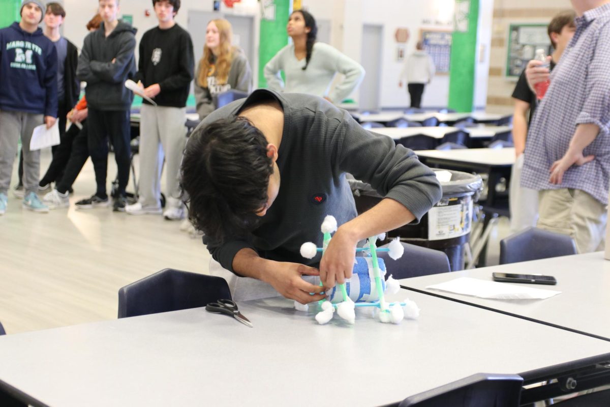 Carefully unwrapping the tape around his delivery system, Fayez Junaid, junior, opens his delivery system to see his egg. If Junaid’s egg breaks in the process of taking it out of the delivery system, he will still get a performance score of zero, even if his egg survived the drop from the third floor.