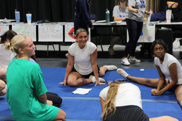 Macie Marsh, senior, laughs as she discusses technique for cheer tryouts on Thursday, April 2. Marsh has been on the cheer team for all four years of her high school career. 