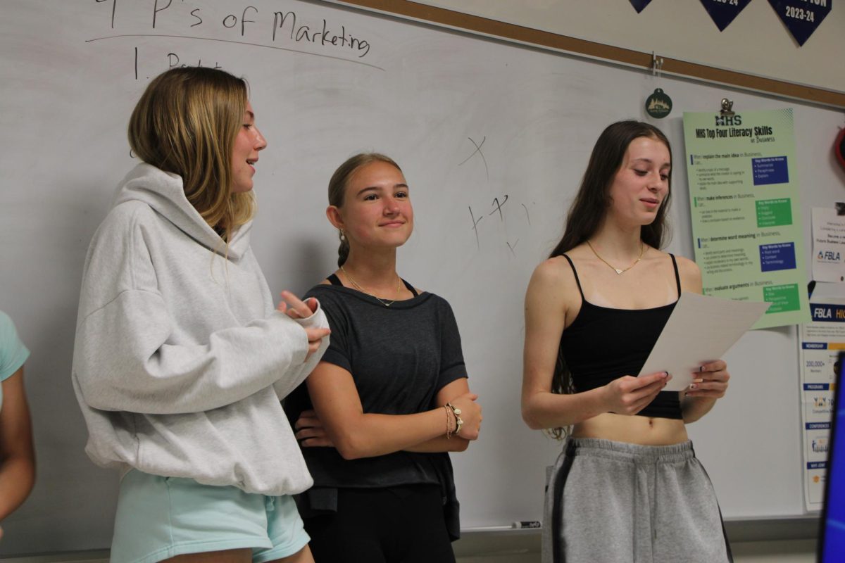 Hannah Schaefer, freshman, Abby Tversland, junior, and Jane Covington, sophomore present on a marketing
plan in Crystal Strate, business teacher’s sixth hour Business Essentials class. Next year, a brand new AP course focused on business and personal finance is to be introduced. 